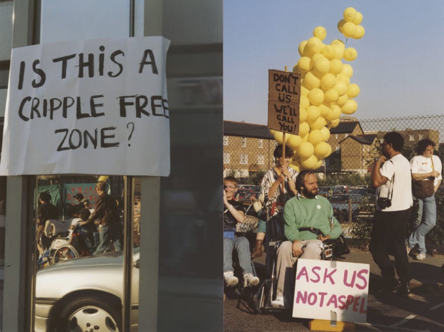 Colour photograph of a group of disabled protesters outside in what looks to be a car park, with blue skies. They are holding placards with slogans on and in the foreground is a sign saying Is this a cripple-free zone?