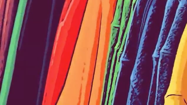 A close up image of different coloured clothes stacked next to eachother.