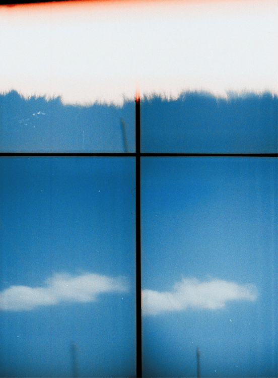 Analogue photography work of a blue sky with white patches