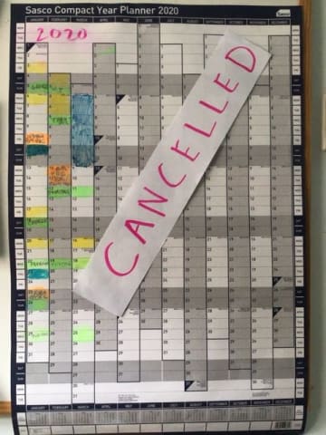 A year planner on the wall with "Cancelled" written across it in red.