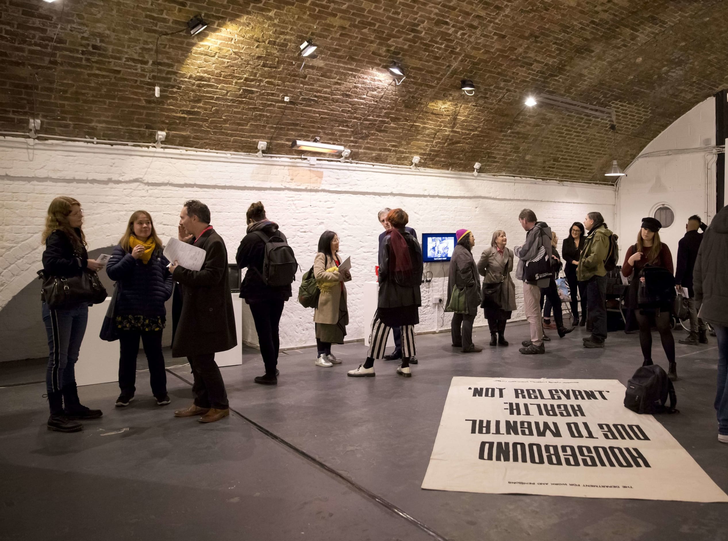 Crowd along side of room chatting to each other at art exhibition Shape Open Retrospective, Hoxton Arches, 2018