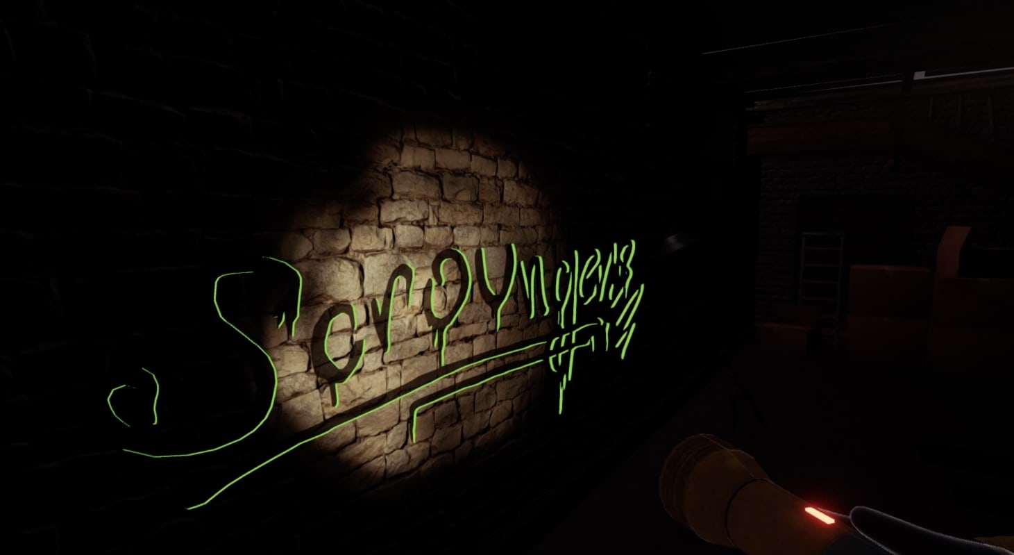 In-game screenshot. Perspective limited by the reach of the torchlight. The torch is being shone directly at a crumbling brick wall, highlighting a round space of visible graffiti. In black, scrawled text, ‘Scroungers’ is written. The text is then further outlined in neon green, indicating it is an interactive object.