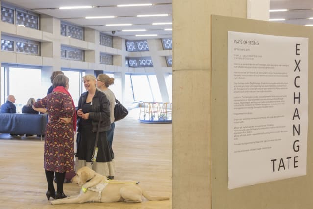 two women in conversation at tate exchange, one with an assistance dog