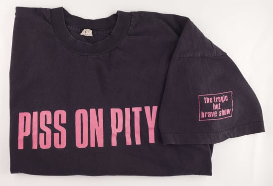 A black shirt with pink text Piss on pity
