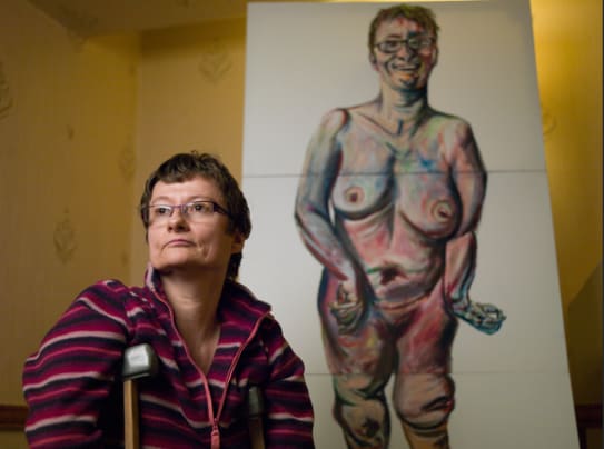 Artist Tanya Raabe in-front of her nude self-portait.